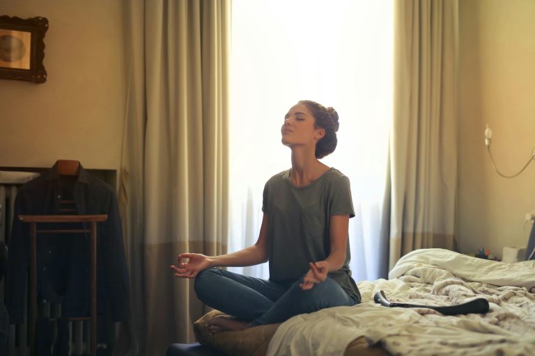 woman on bed meditating